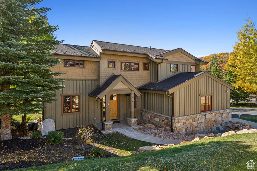 View of front of property with a front lawn and central AC unit