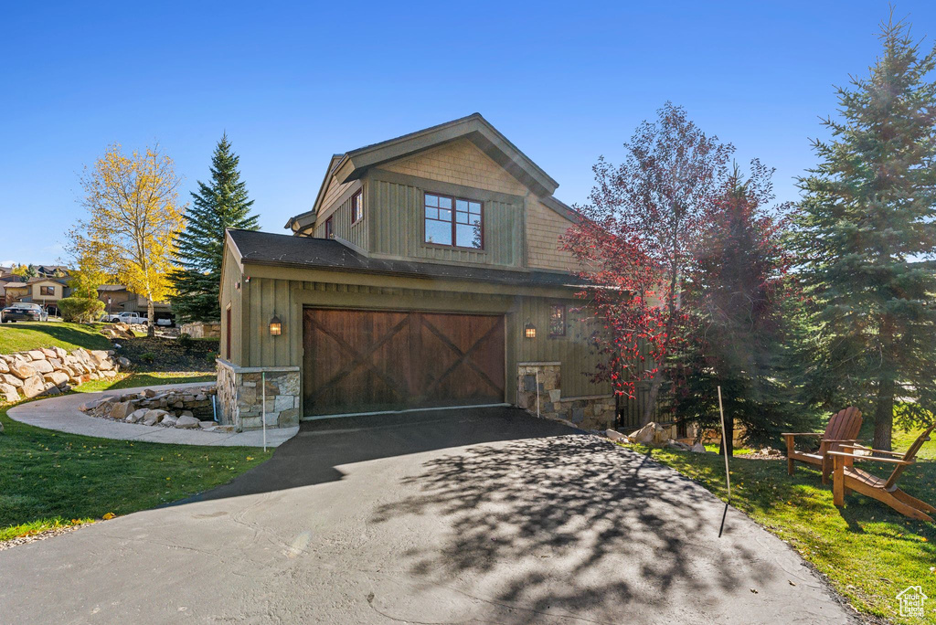 View of property exterior with a yard and a garage