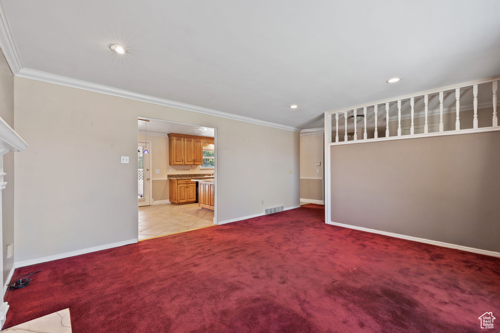 Unfurnished living room with crown molding and light carpet