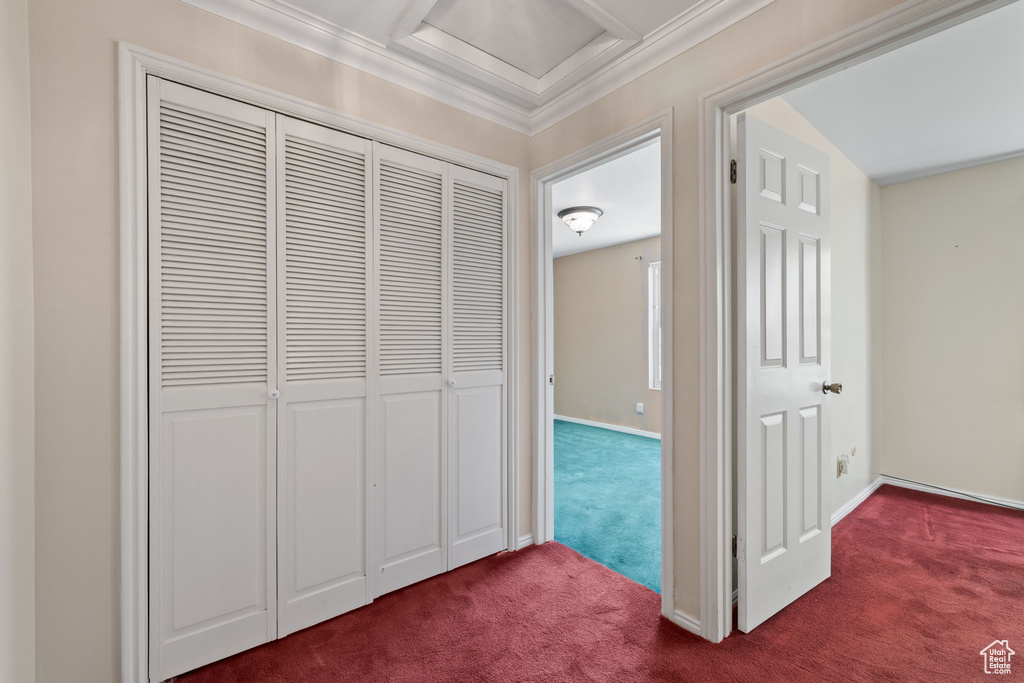 Corridor with ornamental molding and dark carpet