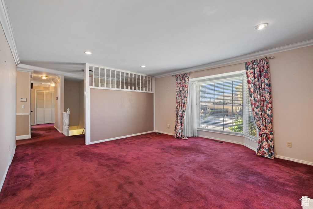 Carpeted spare room featuring ornamental molding