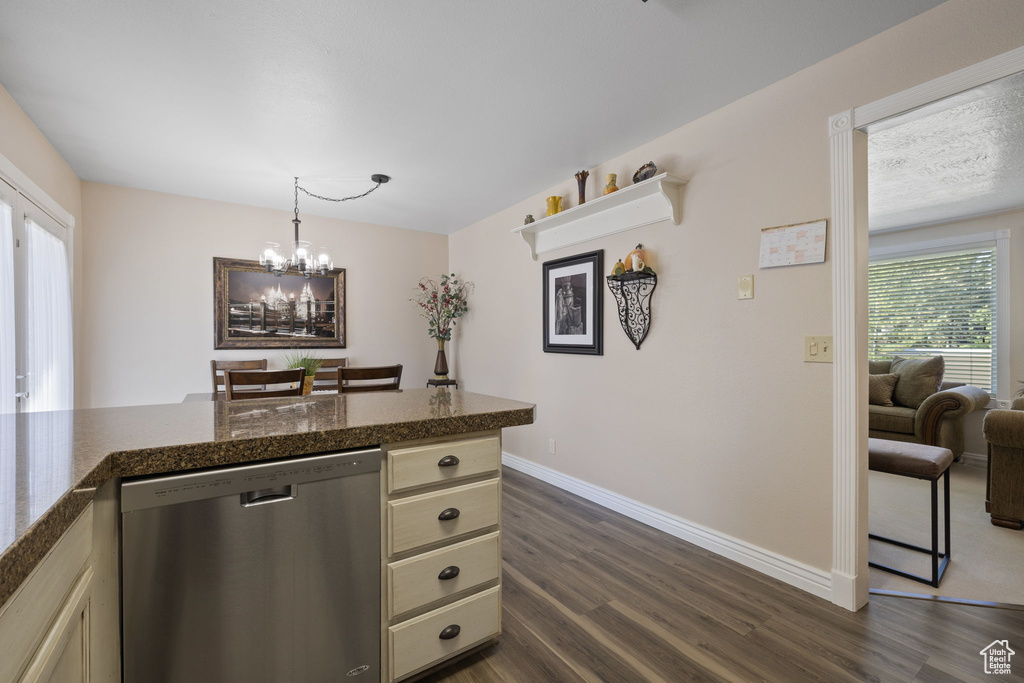 Kitchen with cream cabinets, dishwasher, dark hardwood / wood-style floors, and hanging light fixtures