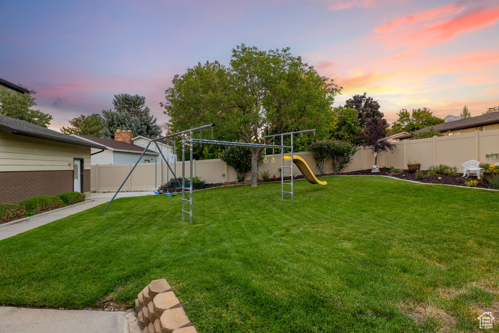 Yard at dusk featuring a playground