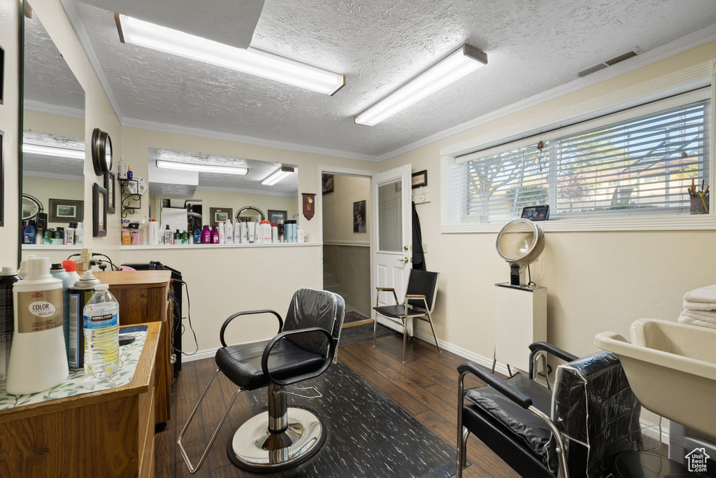 Interior space featuring a textured ceiling, ornamental molding, and dark hardwood / wood-style flooring