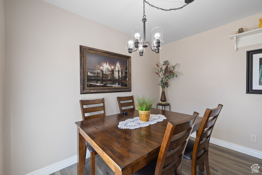 Dining room featuring dark hardwood / wood-style flooring and an inviting chandelier