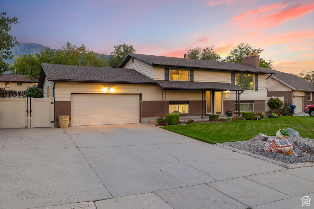 View of front of home with a yard and a garage