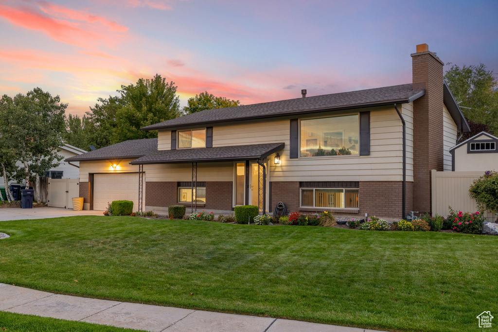 View of front of home featuring a lawn and a garage