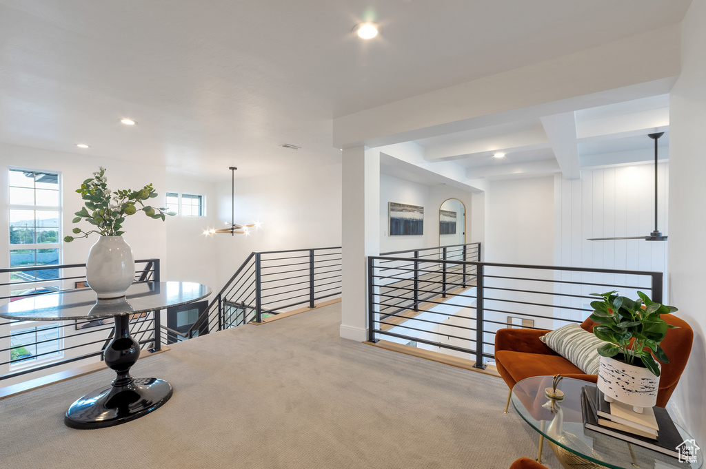 Hall featuring an inviting chandelier, carpet floors, and beamed ceiling