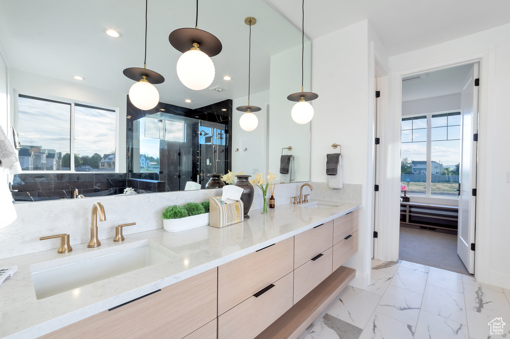 Bathroom with vanity, an enclosed shower, a healthy amount of sunlight, and tasteful backsplash