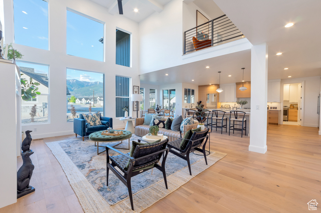 Living room featuring a towering ceiling and light wood-type flooring