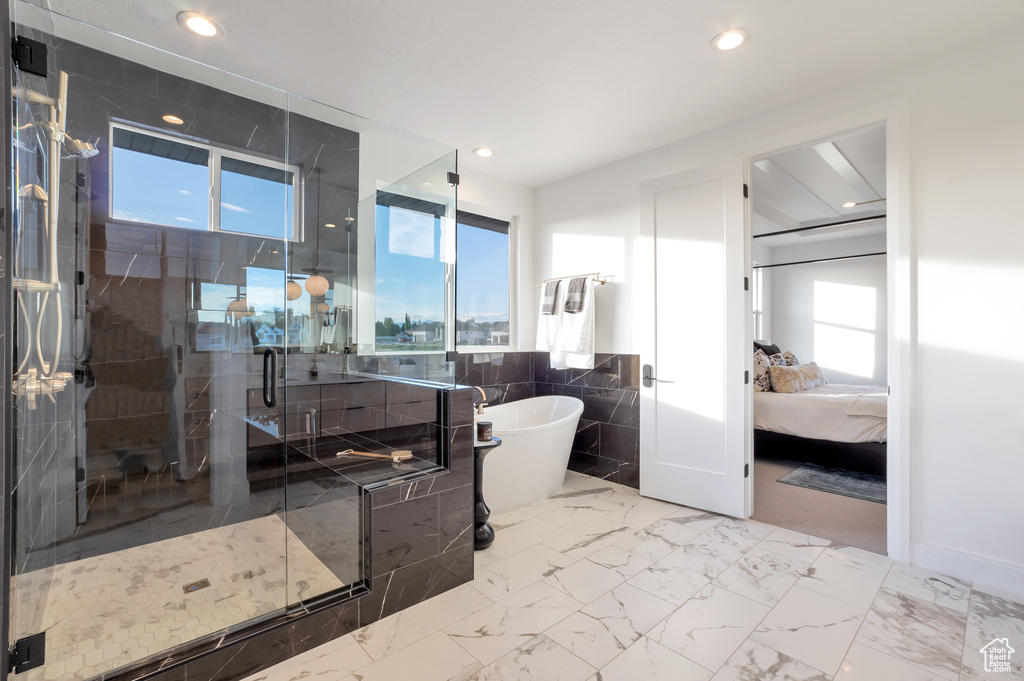 Bathroom featuring plenty of natural light and separate shower and tub