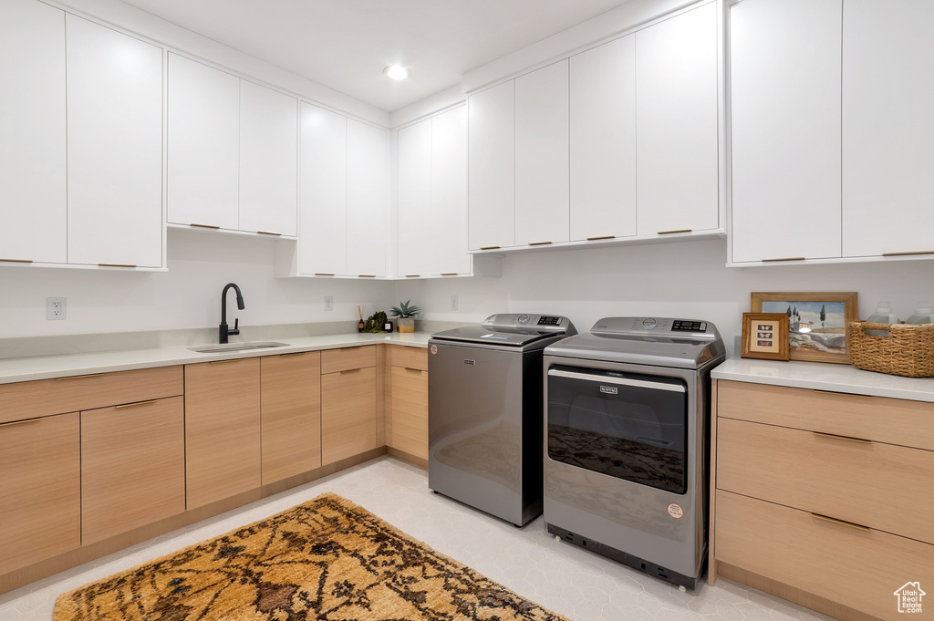 Laundry room featuring cabinets, sink, and separate washer and dryer