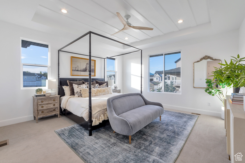 Bedroom with light carpet, multiple windows, and ceiling fan