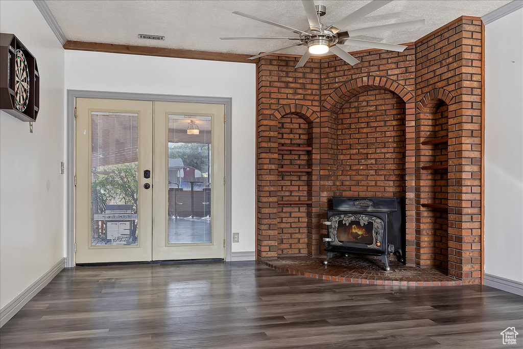 Unfurnished living room with french doors, a textured ceiling, ceiling fan, crown molding, and dark hardwood / wood-style floors