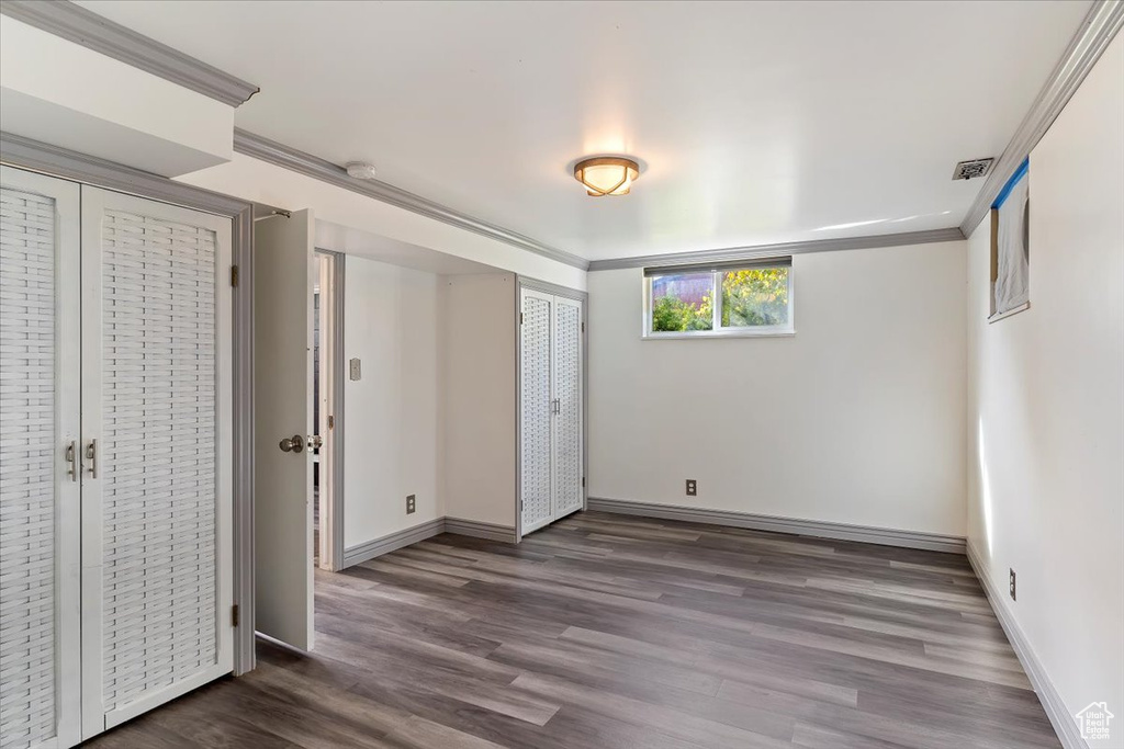 Unfurnished bedroom with wood-type flooring and ornamental molding