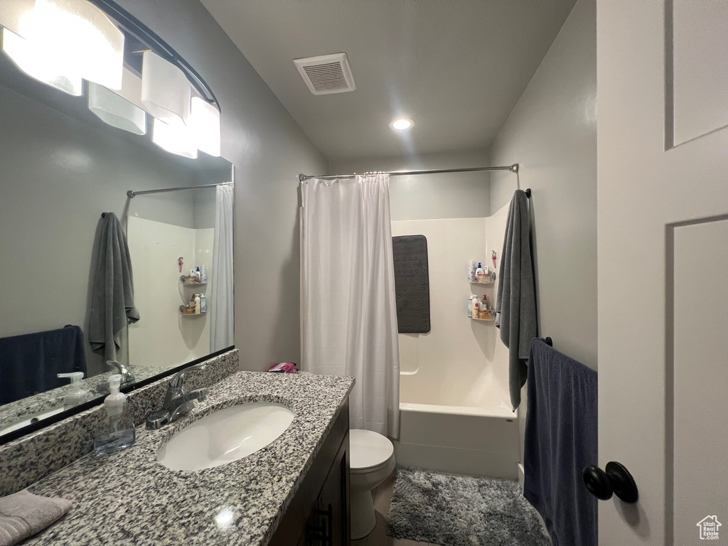 Full bathroom with vanity, toilet, and shower / tub combo with curtain