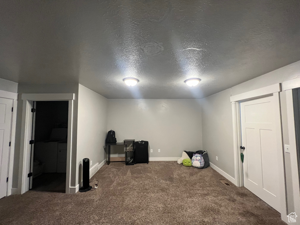 Interior space with a textured ceiling and carpet