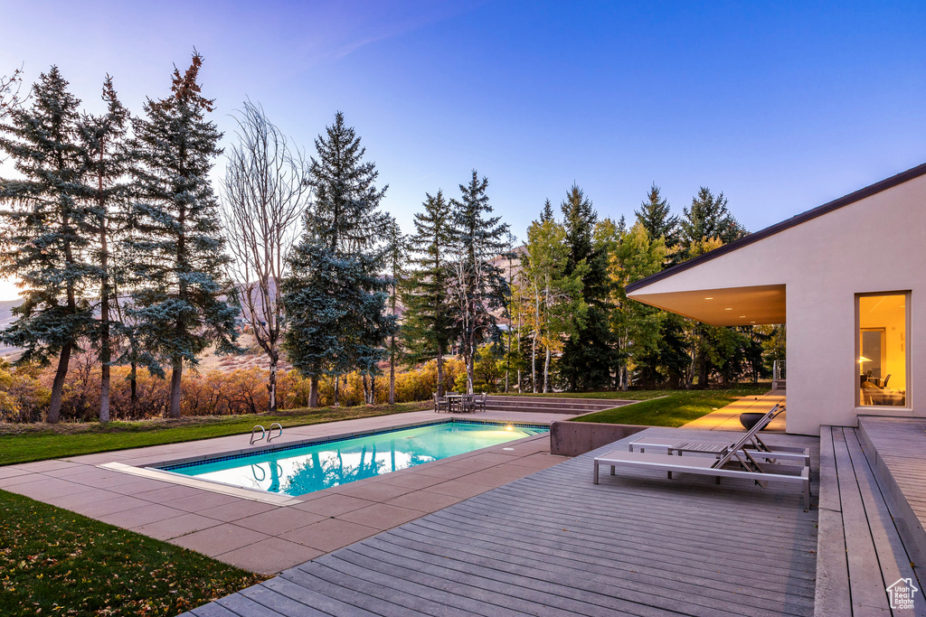 View of pool with a lawn and a wooden deck