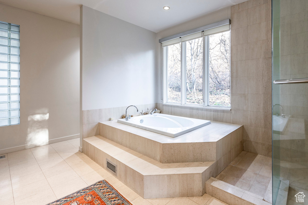 Bathroom with independent shower and bath and tile patterned flooring