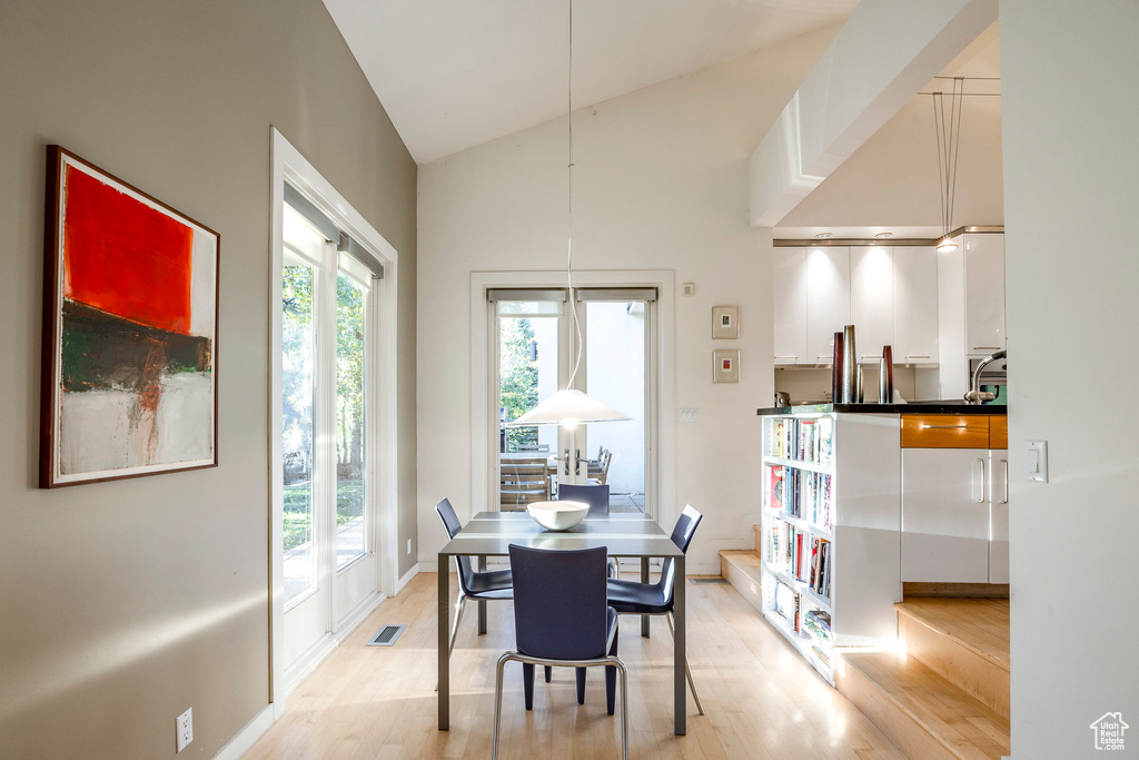 Dining space featuring light hardwood / wood-style flooring and vaulted ceiling