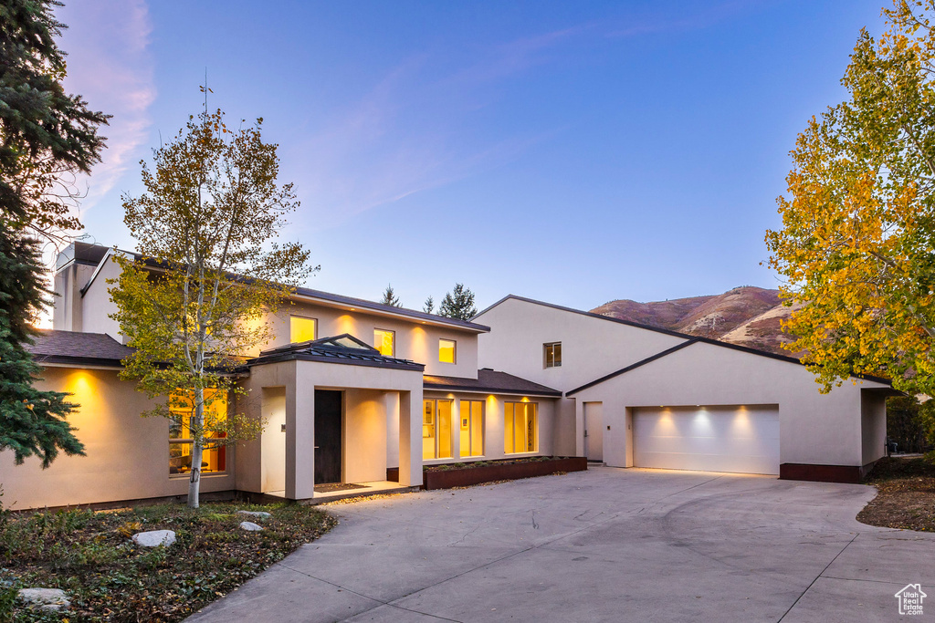 View of front of home with a mountain view and a garage