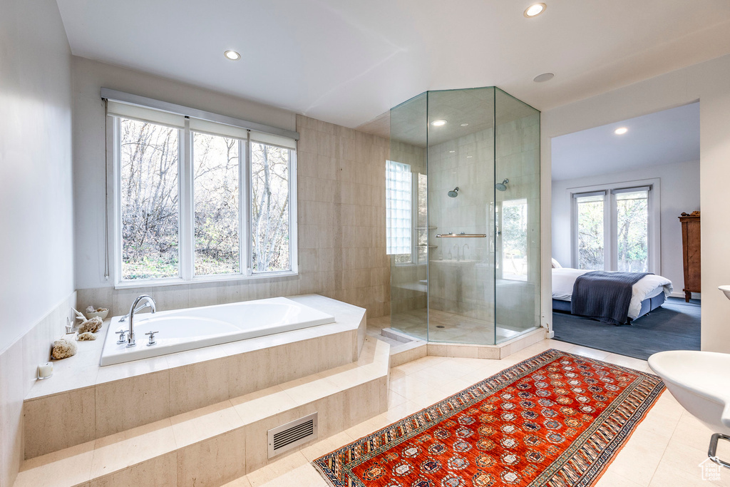 Bathroom featuring a wealth of natural light, tile patterned floors, and independent shower and bath