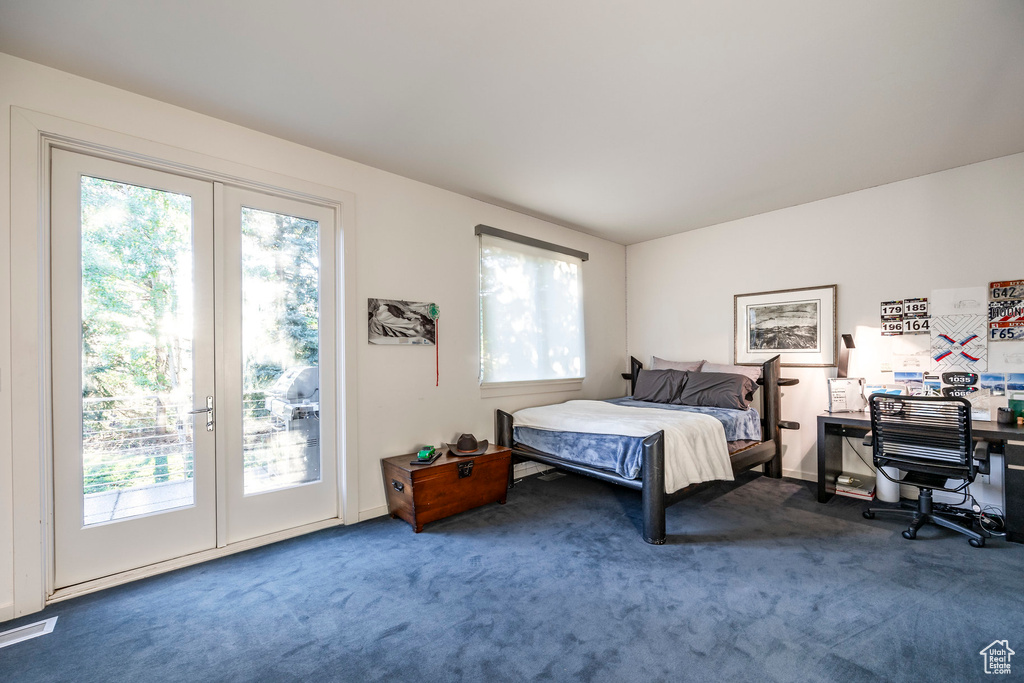 Bedroom with french doors, multiple windows, carpet floors, and access to outside