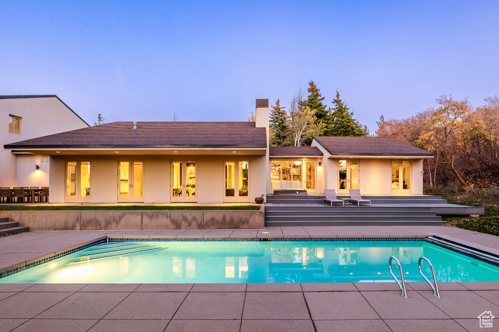 Back house at dusk featuring a patio