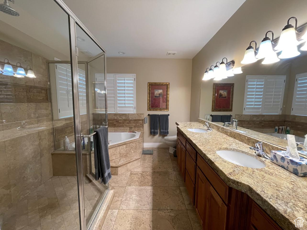 Full bathroom featuring vanity, toilet, and separate shower and tub