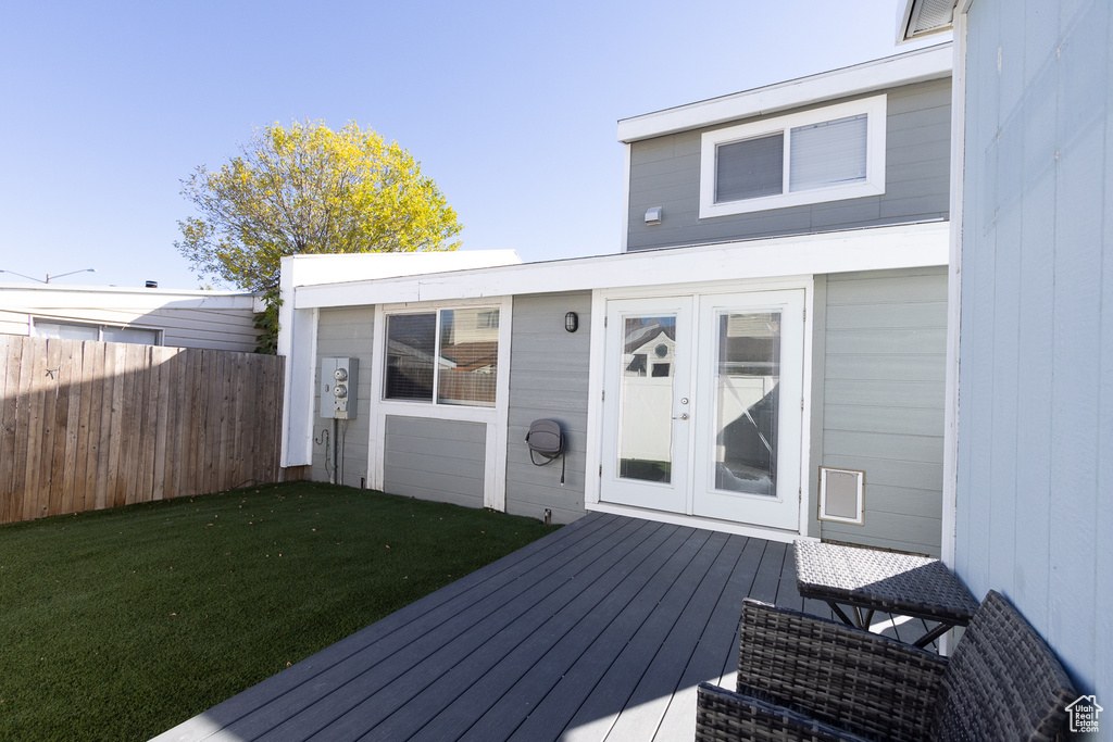 Wooden terrace featuring french doors and a yard