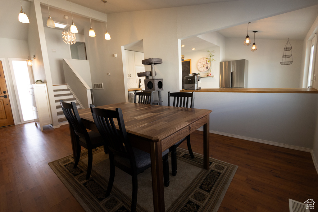 Dining space featuring vaulted ceiling and dark hardwood / wood-style floors