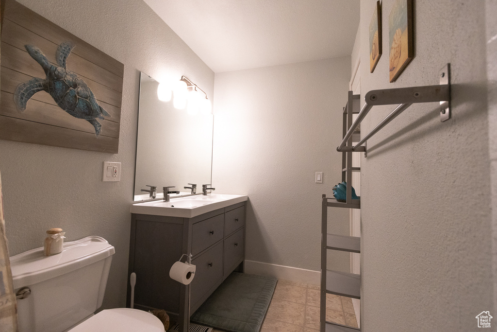 Bathroom with vanity, toilet, and tile patterned floors