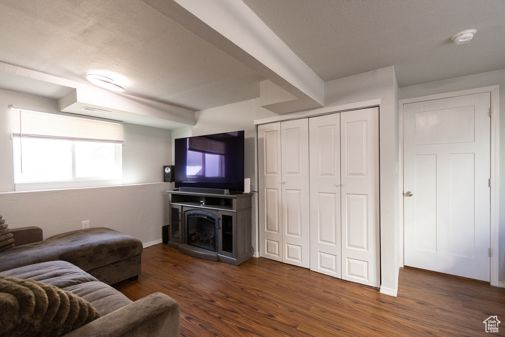 Living room featuring a textured ceiling and dark wood-type flooring