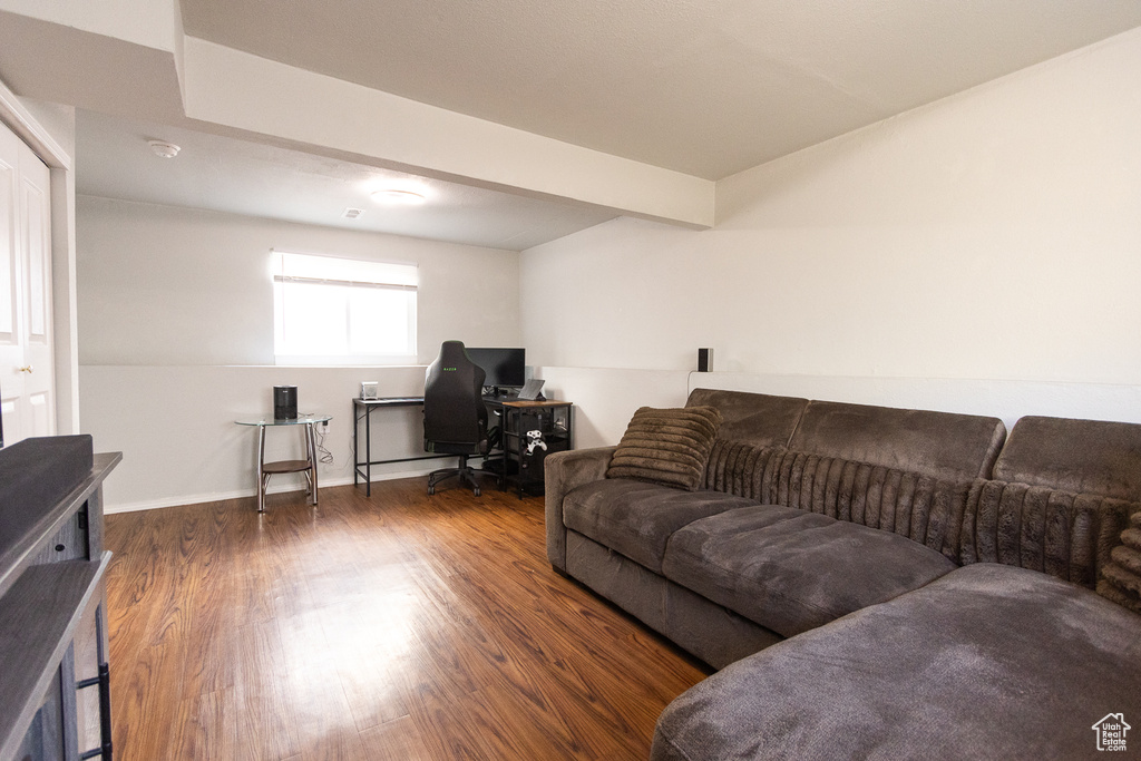 Living room with lofted ceiling with beams and dark hardwood / wood-style floors