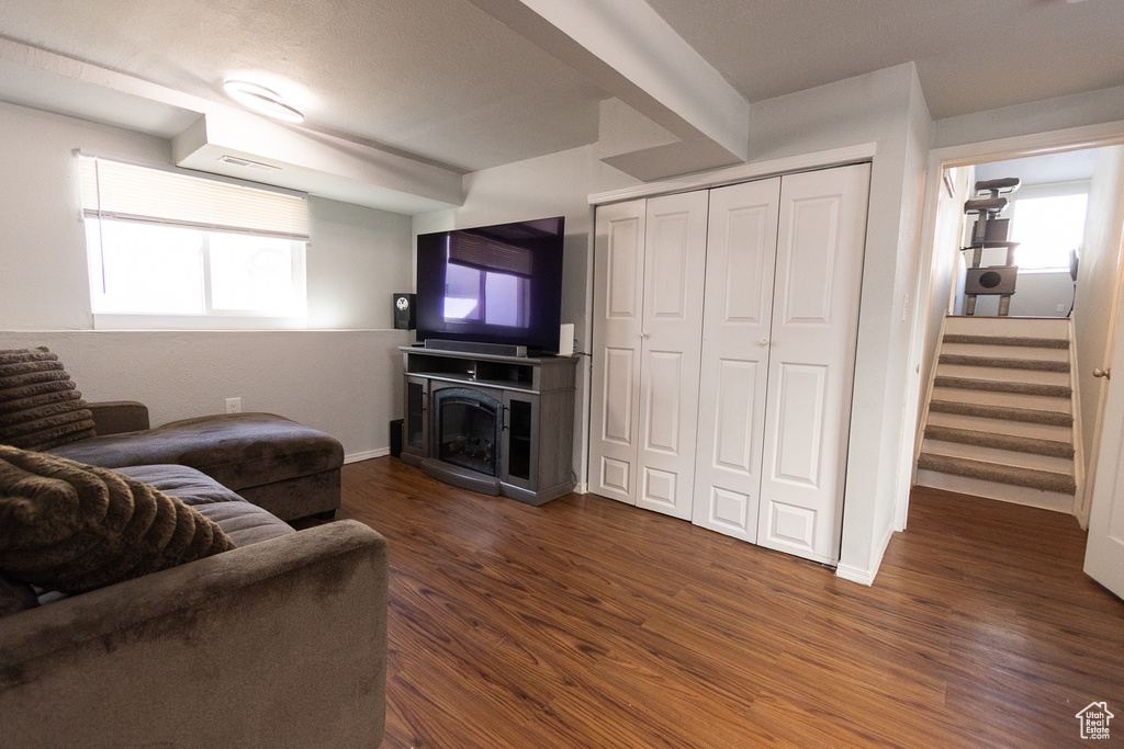 Living room featuring dark wood-type flooring and a healthy amount of sunlight