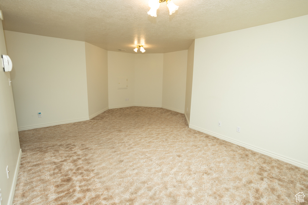 Carpeted empty room featuring a textured ceiling