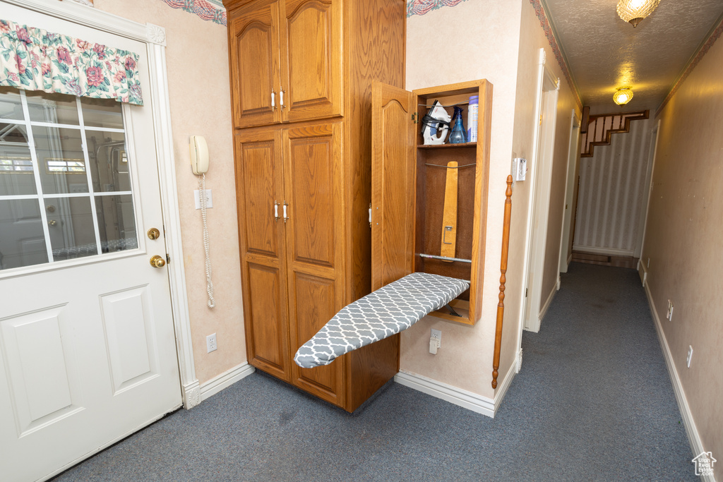 Interior space featuring a textured ceiling and dark carpet