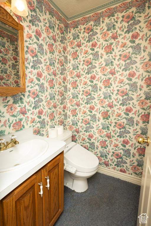 Bathroom with vanity, toilet, and a textured ceiling