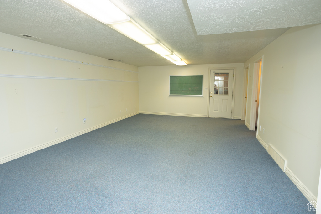 Carpeted empty room with a textured ceiling