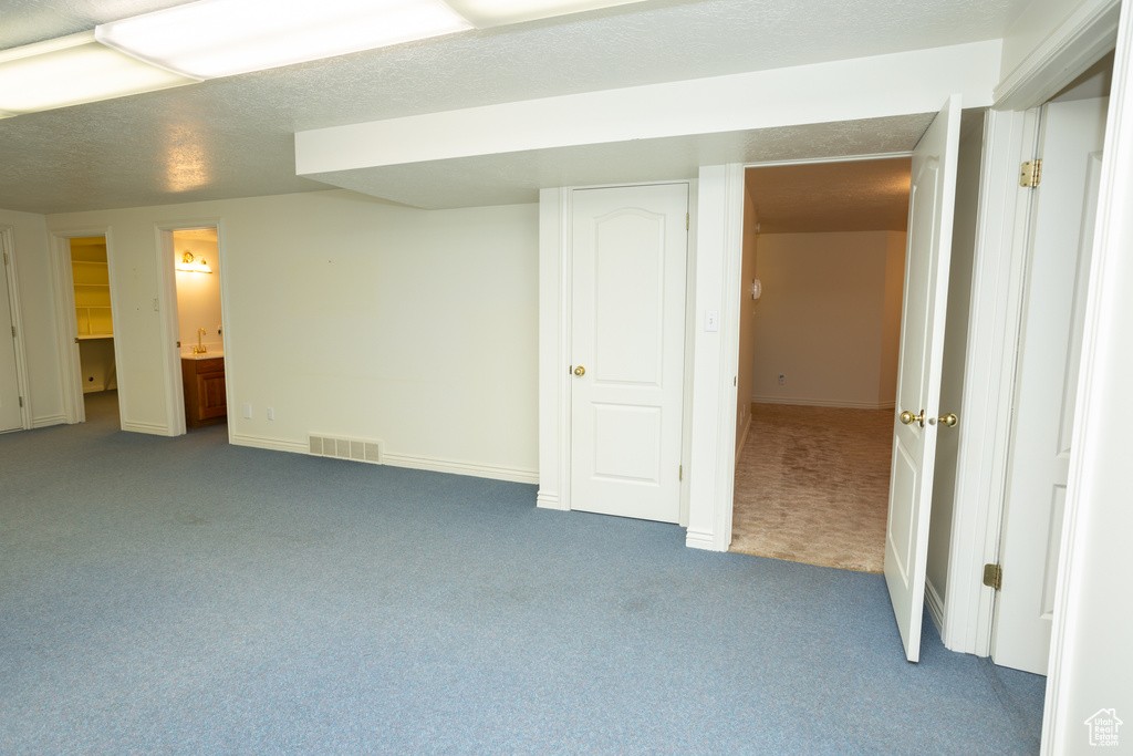 Interior space with carpet, a textured ceiling, and ensuite bath