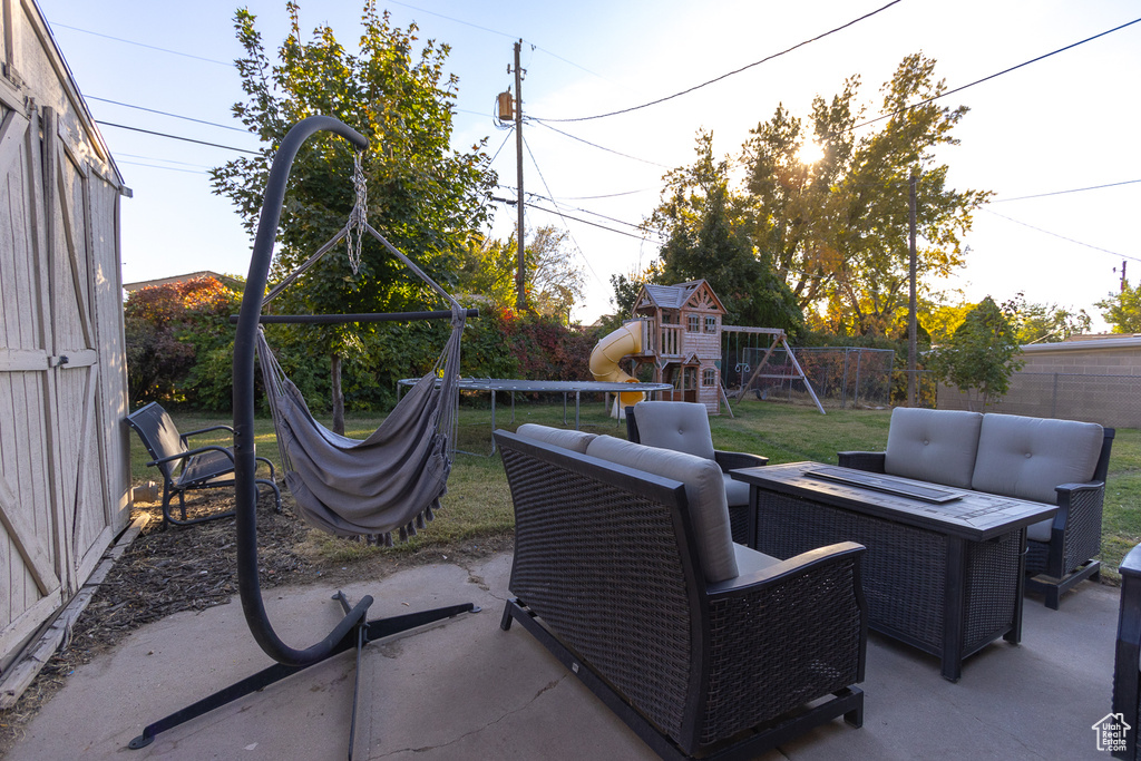 View of patio / terrace featuring an outdoor living space with a fire pit and a playground