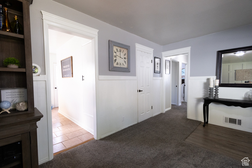 Corridor featuring dark colored carpet