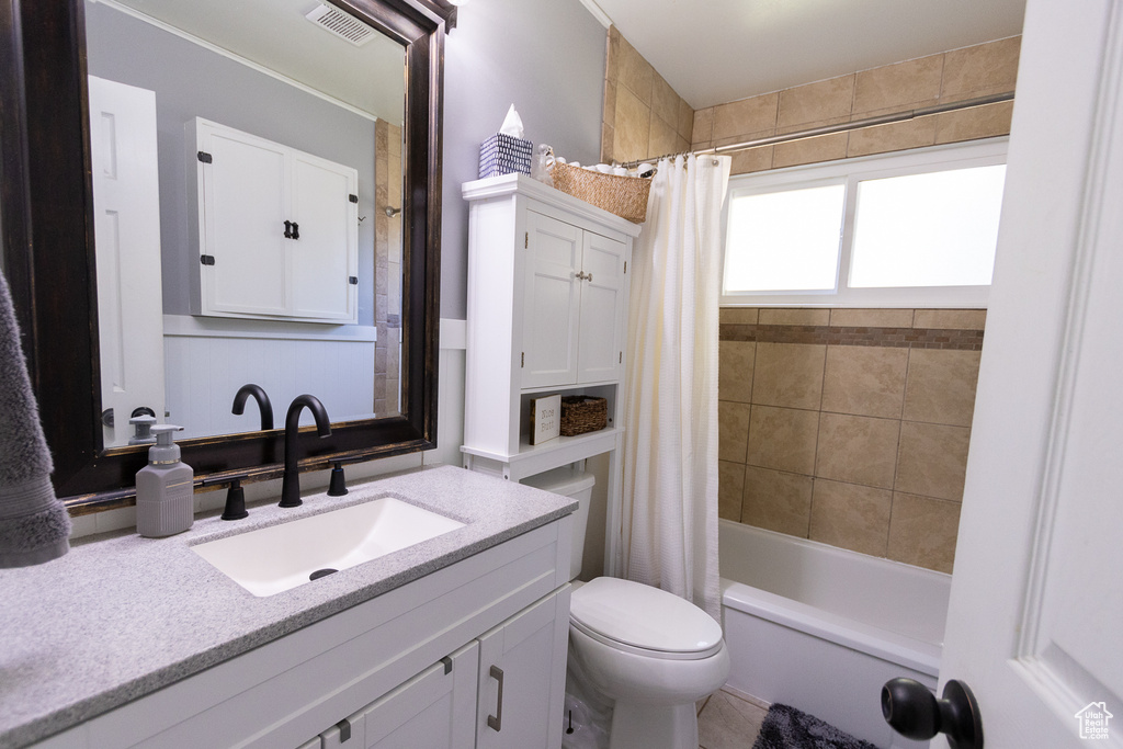 Full bathroom with vanity, toilet, and shower / bathtub combination with curtain