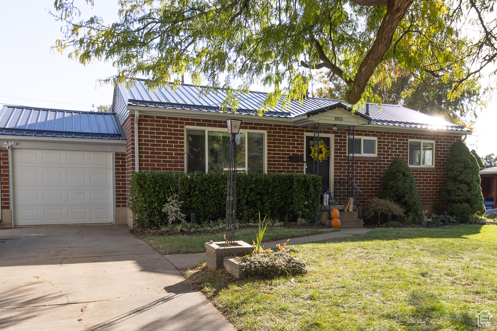 Ranch-style home with a front lawn and a garage