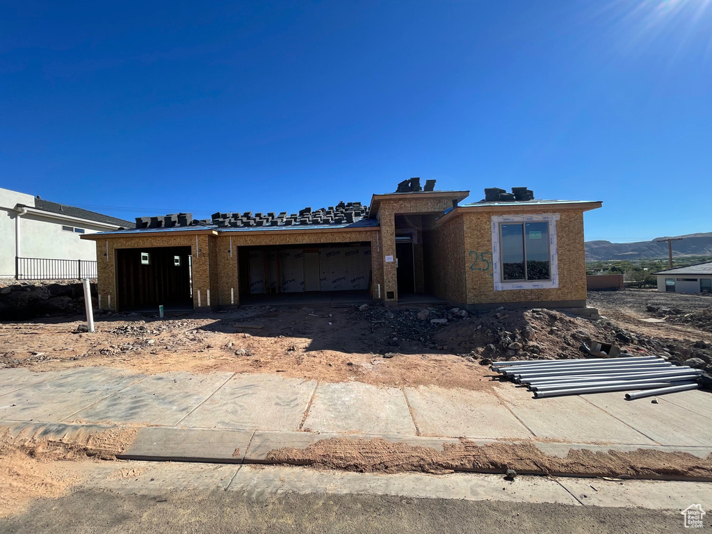 Property in mid-construction featuring a garage and a mountain view