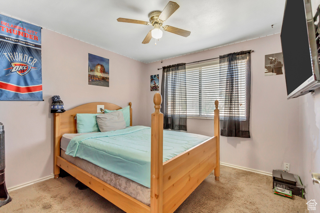 Carpeted bedroom featuring ceiling fan