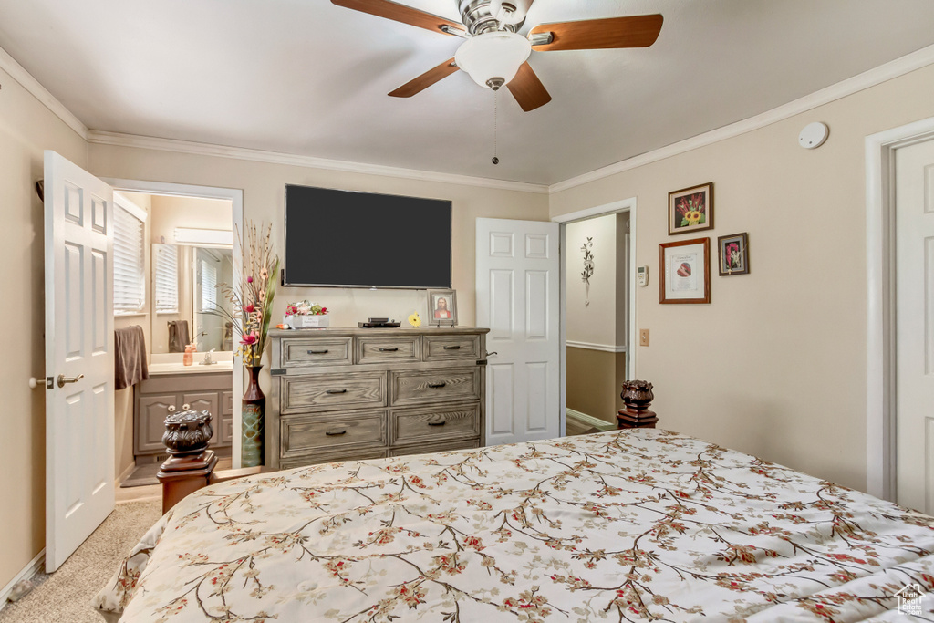 Bedroom featuring ornamental molding, light colored carpet, connected bathroom, and ceiling fan