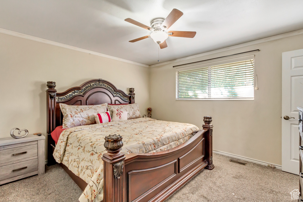 Bedroom featuring crown molding, light colored carpet, and ceiling fan