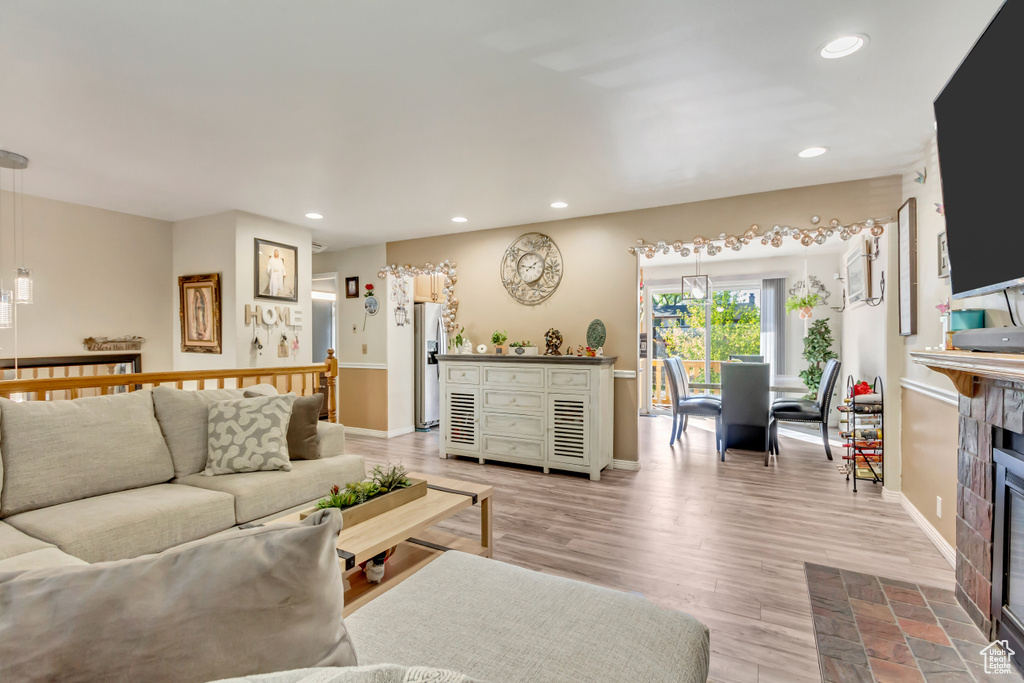 Living room featuring a tiled fireplace and light hardwood / wood-style flooring