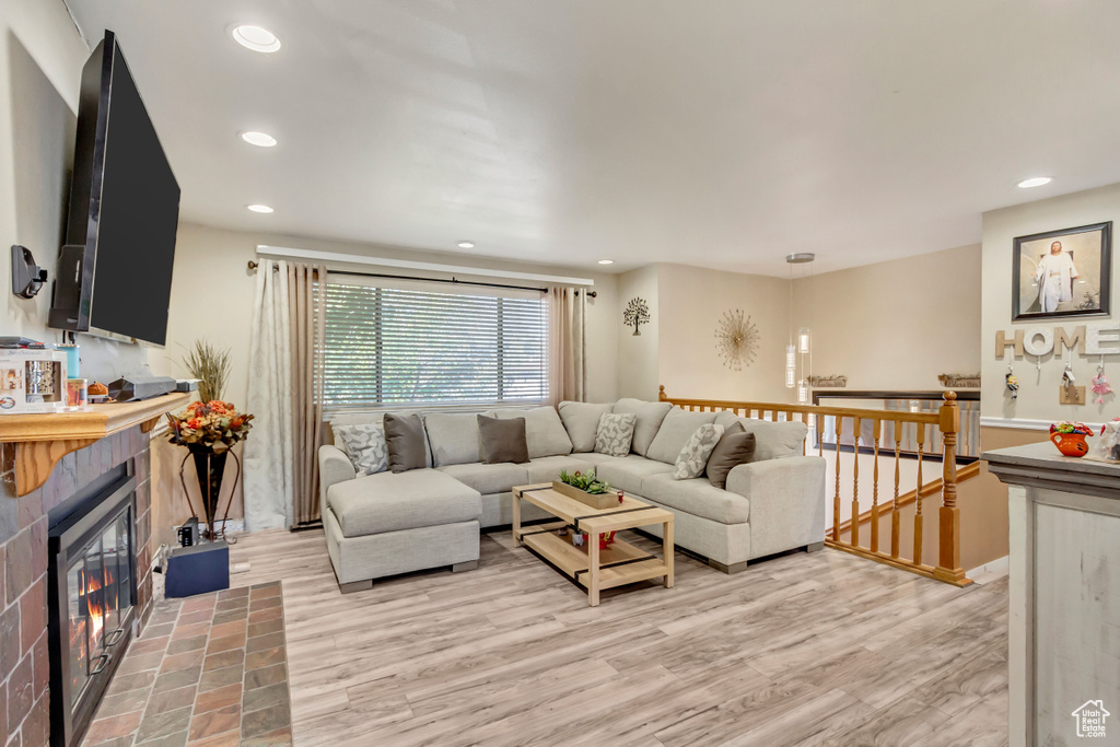 Living room with hardwood / wood-style floors and a tile fireplace